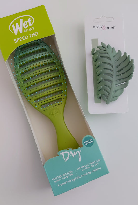 Green hairbrush with packaging on a white background